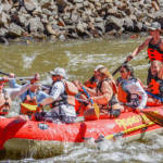 Family rafting under golden aspen trees on Big Thompson River in fall - Colorado mountain reflections, autumn colors, and gentle rapids with Rapid Transit Rafting near Estes Park