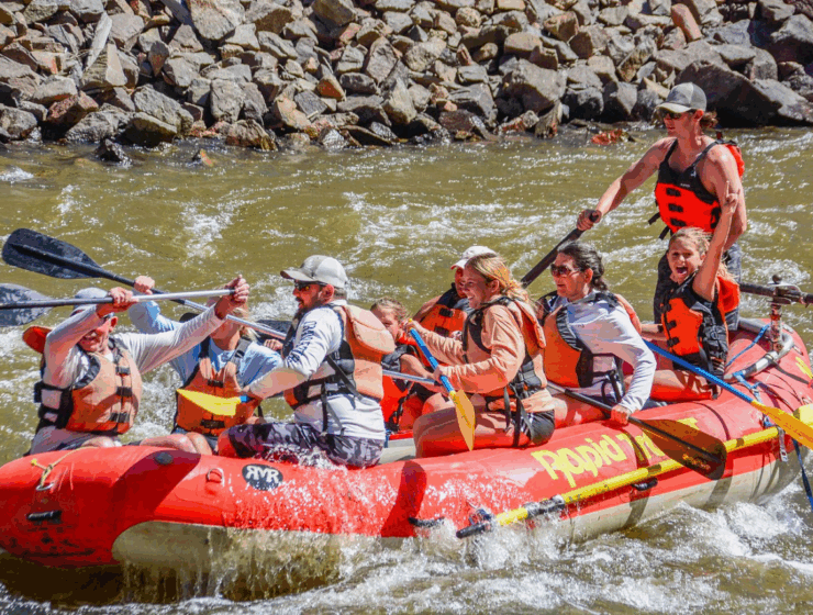 Family rafting under golden aspen trees on Big Thompson River in fall - Colorado mountain reflections, autumn colors, and gentle rapids with Rapid Transit Rafting near Estes Park