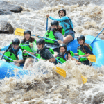 Happy family with children rafting on Big Thompson River near Estes Park, Colorado - gentle rapids, safety gear, and mountain views